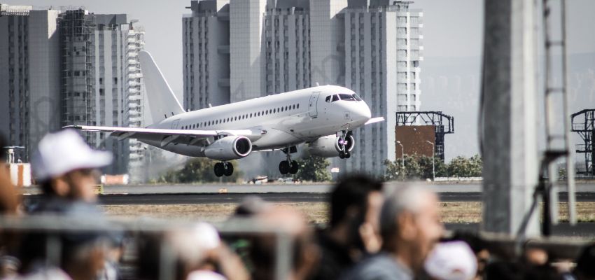 A white airplane is taking off from an airport.