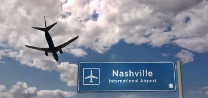 Aeroplane flying past nashville airport sign board